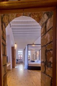 una grande camera con un letto e un muro di mattoni di Villa Myrto a Líndos