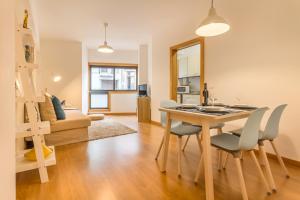 a dining room and living room with a table and chairs at Camões Executive Flat in Porto