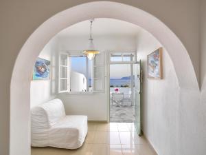 a white room with a white chair and a window at Alikaki Kimolos in Kimolos