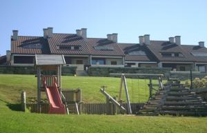 a playground in a field with houses in the background at COMPEJO RAEIROS O GROVE, S Vicente do Mar in Balea