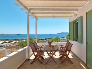 a patio with a table and chairs and the ocean at Alikaki Kimolos in Kimolos