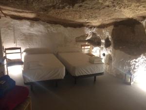 アルカラ・デル・フカルにあるCasa Cueva Las Tinajas de Nayaの洞窟内のベッド2台が備わる部屋