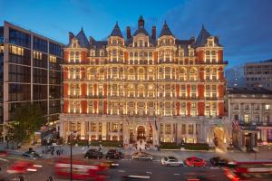 a lit up building with cars in front of it at Mandarin Oriental Hyde Park, London in London