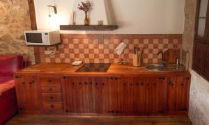 eine Küche mit einer Theke mit einer Spüle und einer Mikrowelle in der Unterkunft Casa Rural Las Tinajas de Naya in Alcalá del Júcar