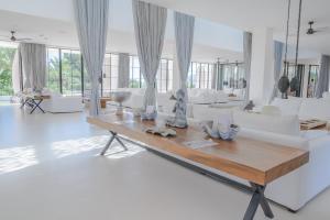 a living room with white furniture and a wooden table at Destino Pacha Ibiza in Talamanca