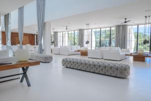 a living room with white furniture and large windows at Destino Pacha Ibiza in Talamanca