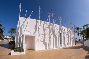 Biały budynek z drzewami na boku w obiekcie Destino Pacha Ibiza w Talamance