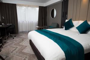 um quarto de hotel com uma cama grande e uma secretária em Crowne Plaza Basingstoke, an IHG Hotel em Basingstoke