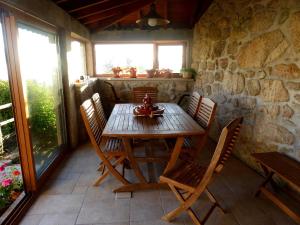 a wooden table and chairs on a patio at Casa da Eira Velha in Vale de Cambra