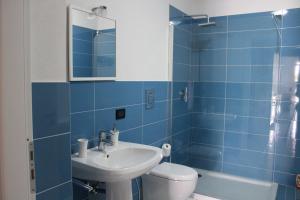 a blue tiled bathroom with a sink and a toilet at Isola del sole, Appartamenti con piscina in Balestrate +55 photos