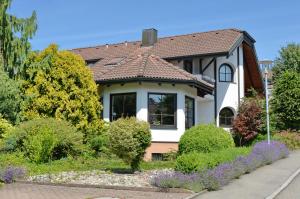 una casa blanca con techo marrón en FeWo Familie Walther, en Markdorf