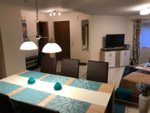 Una sala de estar con una mesa y sillas y un televisor. en FeWo Familie Walther, en Markdorf