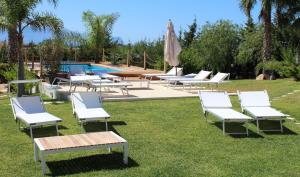 - un groupe de chaises longues et une piscine dans l'établissement Isola del sole, Appartamenti con piscina, à Balestrate