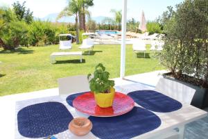 une table avec une plaque et une plante en pot dans l'établissement Isola del sole, Appartamenti con piscina, à Balestrate