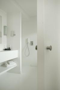 a white bathroom with a shower and a sink at VixX Suites in Mechelen