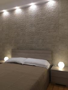 a bedroom with a bed with two night stands and two lights at Luxurious Street Apartments in Catania