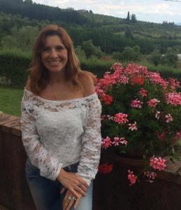 a woman standing next to a pot of flowers at B & B San Jacopo in Santomato 