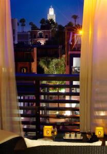 a window with a view of a city at night at Hôtel & Ryads Barrière Le Naoura in Marrakesh