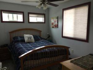 a bedroom with a bed and a ceiling fan at Eycat Lodging Company Guest House in Wapiti