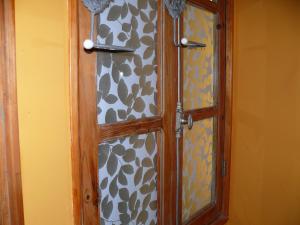 une armoire avec une porte en verre dans une pièce dans l'établissement Chambres d'Hôtes du Clos Semper Felix, à Sainte-Bazeille