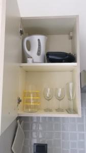 a cupboard with wine glasses and other kitchen items at Luxurious Street Apartments in Catania