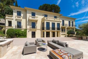 ロクブリュヌ・カップ・マルタンにあるLuxurious Villa Overlooking Monacoの大きな家で、正面にパティオがあります。