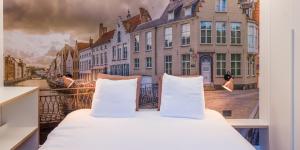 a bed in a room with a picture of a city at Hotel Marcel in Bruges