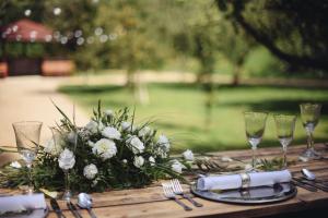 Una mesa de madera con un arreglo floral y copas de vino. en Savoia Castle, en Škvorec