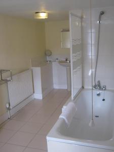 a bathroom with a shower and a tub and a sink at Rose and Crown Hotel in Haverhill