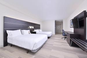 Holiday Inn Express Mystic, an IHG Hotel في ميستيك: غرفة فندقية بسريرين وتلفزيون بشاشة مسطحة
