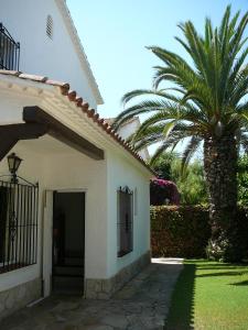 eine Palme neben einem weißen Gebäude mit einer Tür in der Unterkunft Sunway Torre La Veleta in Sitges