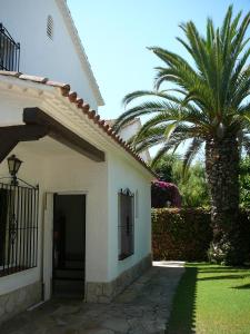 a palm tree next to a white building with a door at Sunway Torre La Veleta in Sitges