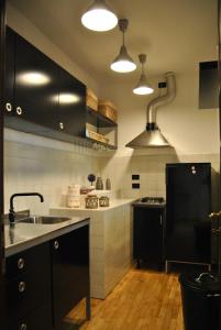 kuchnia z czarnymi szafkami i czarną lodówką w obiekcie Appartamento Posta Vecchia w mieście Pistoia