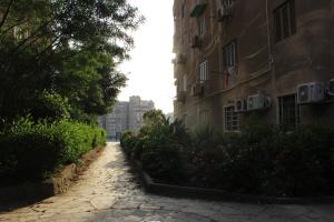 a cobblestone alley between two tall buildings at Apartment at Milsa Nasr City, Building No. 21 in Cairo