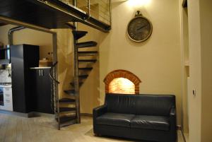 a living room with a couch and a clock on the wall at Appartamento i Fabbri in Pistoia
