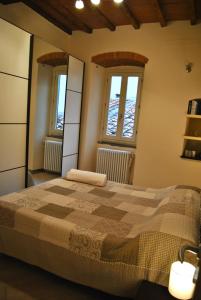 a bedroom with a bed and two windows at Appartamento i Fabbri in Pistoia