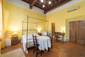 
a room with a bed, table, chairs and a window at La Residenza del Proconsolo in Florence
