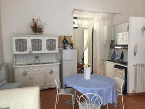 a kitchen with a table and a white refrigerator at Casa Maria in Salerno