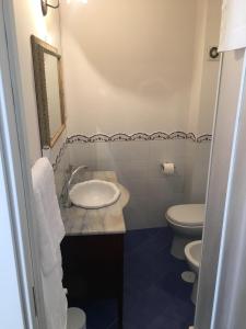 a bathroom with a sink and two toilets at Casa Maria in Salerno