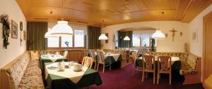 a dining room with tables and chairs and lights at Pension Bergland in Lech am Arlberg