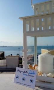 una caja de donuts en una mesa con una señal en B&B Acqua di Sale, en Manfredonia