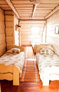 a room with two beds in a wooden cabin at Tsisarske Urochyshe in Rozgirche