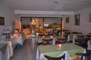 een restaurant met tafels en stoelen met groene tafelkleden bij Bahía Pindó in Punta Del Diablo