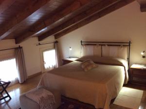 a bedroom with a large bed and two windows at La Dogana in Portogruaro