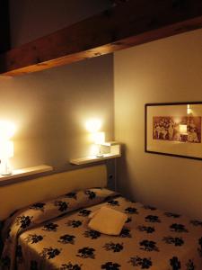 a bedroom with a bed and two lights on the wall at La Dogana in Portogruaro