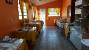 a restaurant with two tables with yellow table cloth at Hospedagem Encanto da Serra Rural in Cambara do Sul