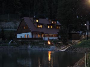 ein Haus in der Nacht neben einem Fluss in der Unterkunft Chata Motyčky in Donovaly