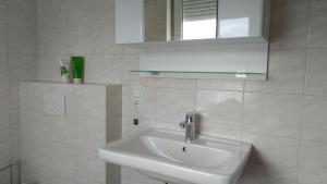 bagno bianco con lavandino e specchio di Fewo Meerestraum a Wilhelmshaven