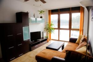 a living room with a couch and a flat screen tv at Apartamentos la Pasarela in Villanueva de Arosa