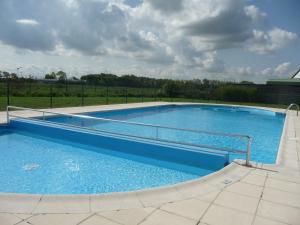 une grande piscine bleue avec une balustrade métallique dans l'établissement Nieuwendamme 14, à Nieuport